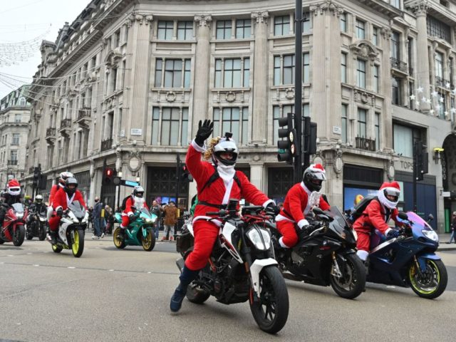 Bikers wearing Santa Claus outfits drive along Oxford Street in London on December 23, 2021. (Photo by JUSTIN TALLIS / AFP) (Photo by JUSTIN TALLIS/AFP via Getty Images)