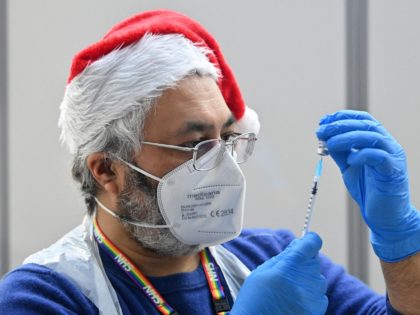 A health worker prepares a dose of the Covid-19 vaccine at a pop-up coronavirus vaccination centre at the Redbridge Town Hall, east London on December 25, 2021. - British Prime Minister Boris Johnson in his Christmas Eve message exhorted the UK public to get jabbed as a "wonderful" gift for …