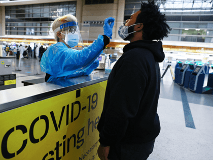 A man receives a nasal swab COVID-19 test at Tom Bradley International Terminal at Los Angeles International Airport (LAX) amid a coronavirus surge in Southern California on December 22, 2020 in Los Angeles, California. The tests are not mandatory with results returned within 24 hours to help travelers avoid quarantining …