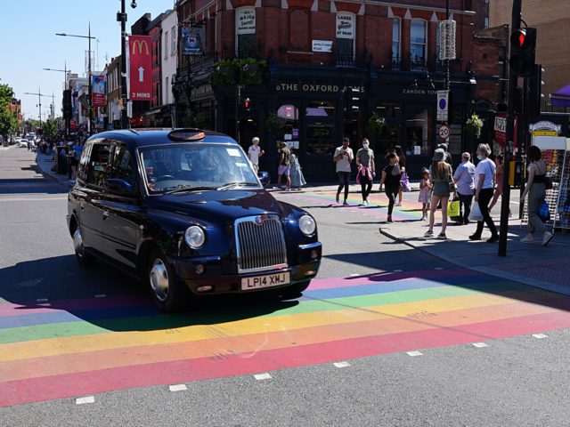 LONDON,UNITED KINGDOM - JUNE 01: A black cab travels over a rainbow crossing in Camden dur
