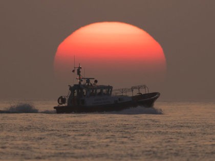 AT SEA, ENGLAND - JULY 22: The Dover Pilot Harbour Patrol boat passes the sun as it rises over the English Channel on July 22, 2021 off the coast of Dover, England. On Monday, 430 migrants crossed the channel from France, a record for a single day. To stem the …