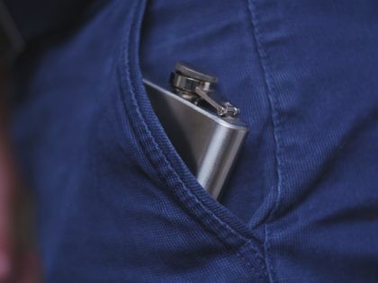 Caucasian Drinking Man Pulling Out and Putting In Shiny Metal Hip Flask of Whiskey Alcohol Concealed in Trousers Pocket