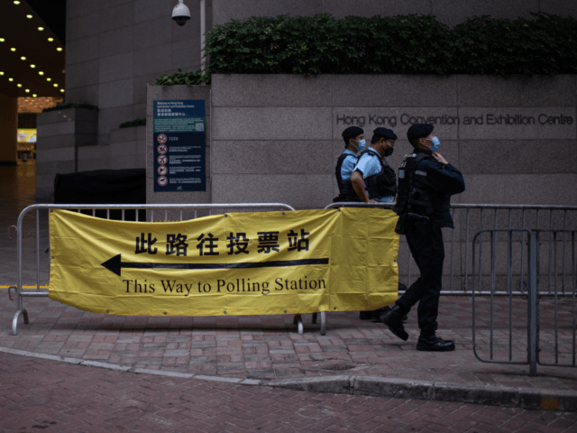 HONG KONG, CHINA - DECEMBER 19: Police officers stand guard outside a polling station on December 19, 2021 in Hong Kong, China. Hong Kong is set to hold its Legislative Council election on December 19, the first citywide poll since Beijing revamped the electoral system to ensure only patriots hold …