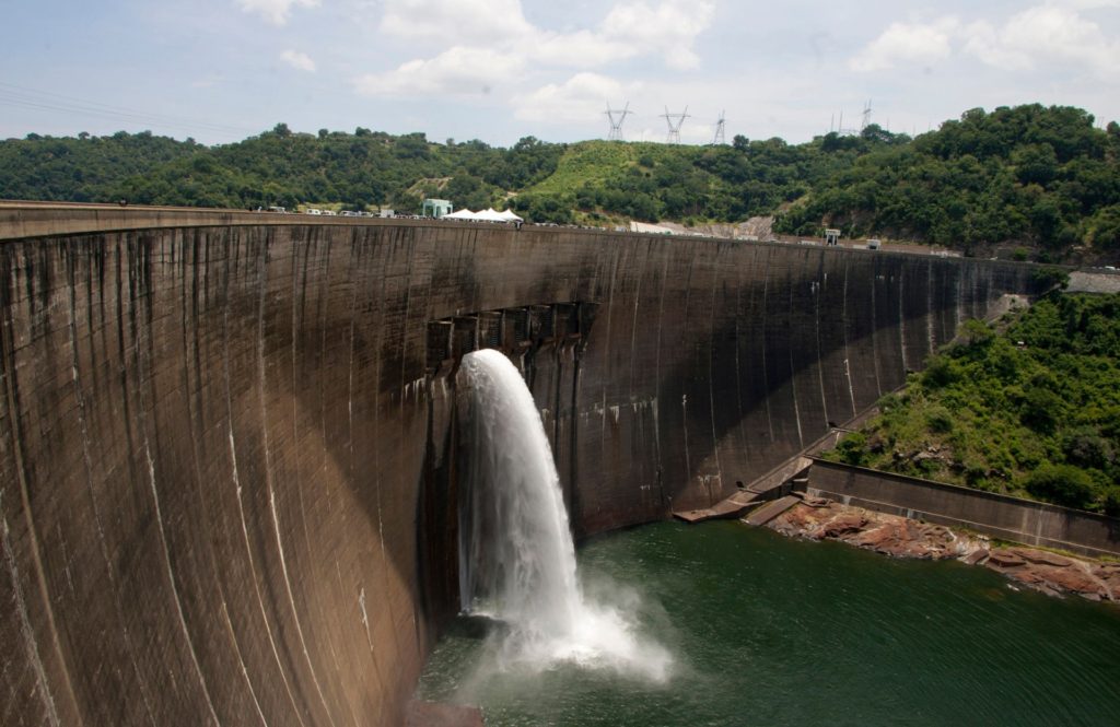 Flood gates on the Kariba Dam wall between Zimbabwe and Zambia open ceremonially on February 20, 2015 after the two neighbors signed $294 million in deals with international investors. The overhaul project of the world's largest man-made dam will fix deformities and cracks in walls that were discovered in a series of assessments. Those threaten to cause the massive structure to collapse -- an eventuality that would carry unimaginable humanitarian and environmental consequences if water in the 181 billion cubic metre capacity reservoir were freed by a massive breach. Given the high stakes involved, the European Union, World Bank, African Development Bank and the Swedish government agreed to bankroll the critical renovation effort. AFP PHOTO / JEKESAI NJIKIZANA / AFP PHOTO / Jekesai NJIKIZANA (Photo credit should read JEKESAI NJIKIZANA/AFP via Getty Images)
