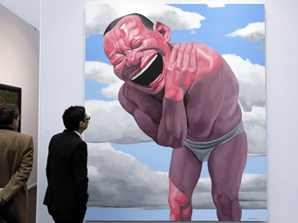 A man looks at a painting by Chinese artist Yue Minjun known as "Blue sky and white clouds", during the 'Art Paris Art Fair', in Paris, on March 26, 2014.