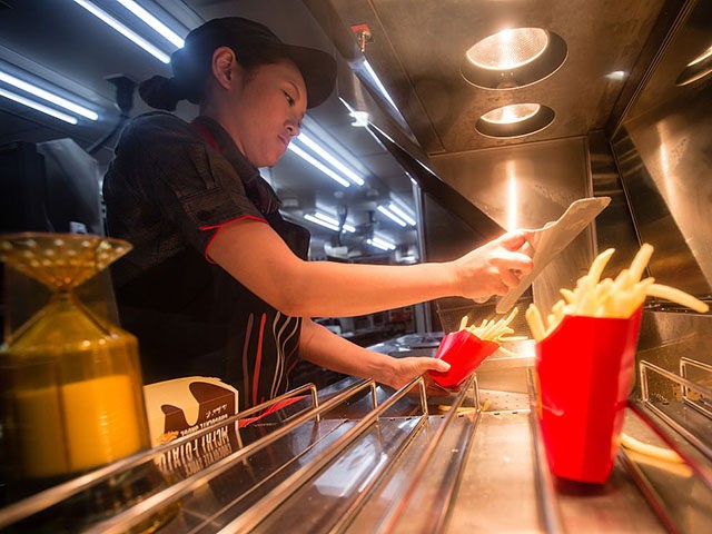 TOKYO, JAPAN - JANUARY 25: McDonald's Japan Swing Manager Miwa Suzuki prepares french fries to be used for McChoco Potato on January 25, 2016 in Tokyo, Japan. The McChoco Potato, McDonald's Japan's special winter menu, french fries covered in chocolate and white chocolate sauces will be available in McDonald's restaurants …