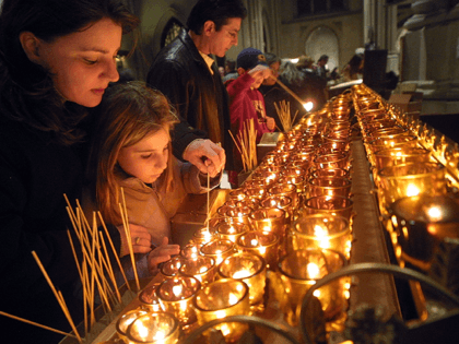Visitors light candles in St. Patrick's Cathedral, a favorite Christmas spot for tourists, December 4, 2001 in New York City. New York is in full holiday swing as the city attempts to recover from the September 11th World Trade Center attacks. (Photo by Mario Tama/Getty Images)