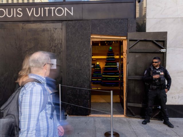SAN FRANCISCO, CA - NOVEMBER 30: A security guard watches the entrance to a Louis Vuitton store, which has had its windows boarded near Union Square on November 30, 2021 in San Francisco, California. Stores have increased security in response to a spike in thefts. (Photo by Ethan Swope/Getty Images)