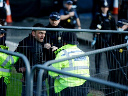 Police officers detain a man after he entered the grounds of the Houses of Parliament in London, Wednesday, Dec. 1, 2021. (AP Photo/David Cliff)