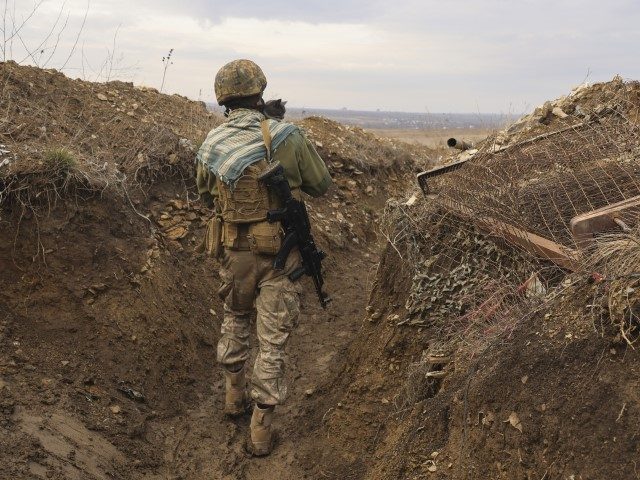 A Ukrainian soldier holds a cat and walks in a trench on the line of separation from pro-Russian rebels near Debaltsevo, Donetsk region, Ukraine, Ukraine Friday, Dec 3, 2021. In this Friday, the Ukrainian defense minister warned that Russia could invade his country next month. Russia-West tensions escalated recently with …