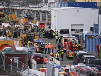 Firefighters, police officers and railway employees are seen at a railway site in Munich, Germany, Wednesday, Dec. 1, 2021. Police in Germany say three people have been injured including seriously in an explosion at a construction site next to a busy railway line in Munich. (Sven Hoppe/dpa via AP)