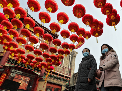 Women wearing face masks to help curb the spread of the coronavirus walk under red lanterns hanging along an alley near the Houhai Lake in celebration of the Lunar New Year in Beijing, Thursday, Feb. 11, 2021. China appeared to be on pace for a slower than normal Lunar New …