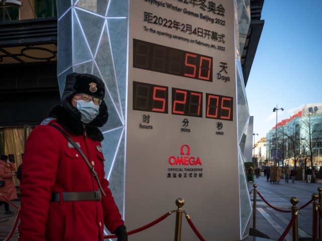 BEIJING, CHINA - DECEMBER 16: A security guard walks in front of a sign marking the countdown to the Beijing 2022 Winter Olympics on December 16, 2021 in Beijing, China. China today marks 50 days to the beginning of the Olympics Games. (Photo by Andrea Verdelli/Getty Images)
