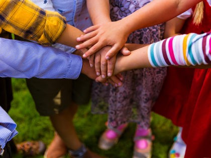 Kids standing in the circle and joining hands together | adoption, family