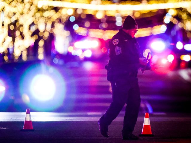 LAKEWOOD, CO - DECEMBER 27: A police officer picks up flares at the Belmar shopping center