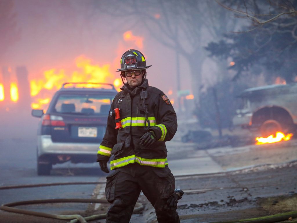 LOUISVILLE, CO - DECEMBER 30: An Arvada firefighter walks back to the firetruck as a fast moving wildfire swept through the area in the Centennial Heights neighborhood on December 30, 2021 of Louisville, Colorado. State officials estimated some 600 homes had already been lost in multiple areas around Boulder County and were fueled by winds that gusted upwards of 100 miles per hour at times during the day. (Photo by Marc Piscotty/Getty Images)