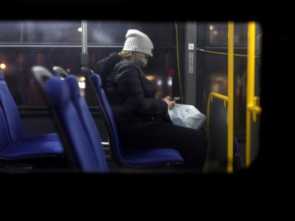WASHINGTON, DC - DECEMBER 21: A woman wears a mask on a Metro Bus December 21, 2021 in Washington, DC. District of Columbia Mayor Muriel Bowser reinstated the city’s indoor mask mandate at 6am on Tuesday and announced a vaccination mandate for government employees after COVID case numbers have surged …