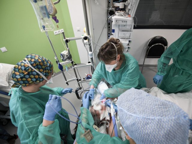 Nurses tend to a Covid-19 patient at the intensive care unit of the Delafontaine AP-HP hospital in Saint-Denis, outside Paris, on December 29, 2021. - A "tidal wave" with a record of more than 200,000 Covid-19 infections in 24 hours : Health Minister Olivier Veran brandished these "dizzying figures" on …