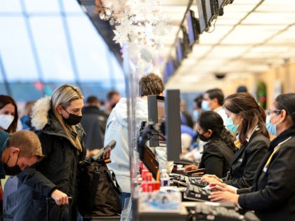 DULLES, VIRGINIA - DECEMBER 27: A woman checks in for her flight at a United Airlines kiosk at the Dulles International Airport on December 27, 2021 in Dulles, Virginia. According to media reports, at least 2,600 more flights were canceled Monday amid the surge in coronavirus cases, which have affected …
