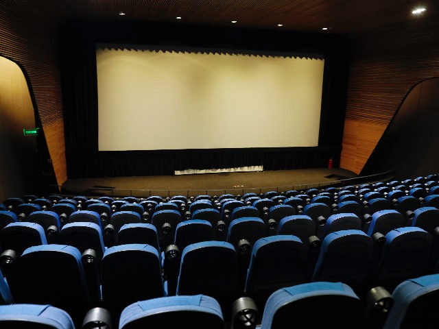 A theater sits empty shortly before the start of a scheduled film showing, attended by a h