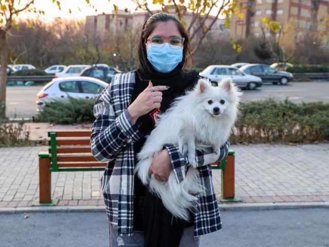 An Iranian woman poses for a picture with her dog at a park in the capital Tehran, on Dece