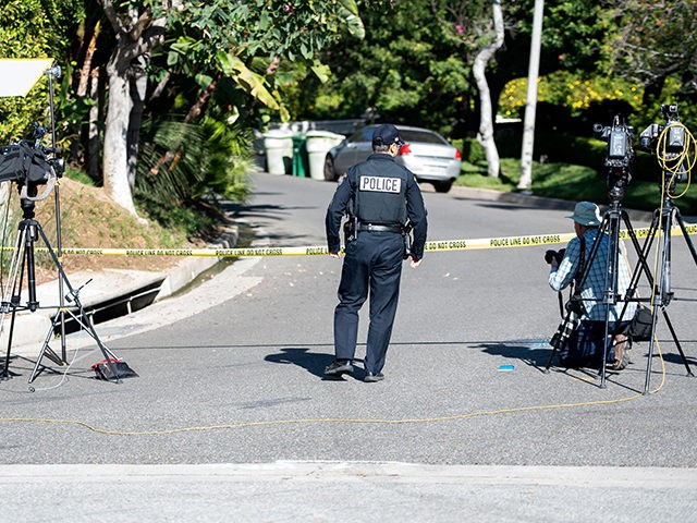 A police officer crosses under police tape as members of the media gather near the 1100 block of Maytor place where Jacqueline Avant's house is at the top of the hill, in Beverly Hills , California on December 1, 2021. - The wife of the man known as the "Godfather …