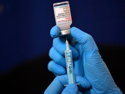 A clinician prepares a dose of a Moderna Covid-19 booster vaccine at a temporary vaccinati