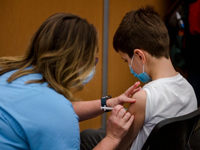 A child, 11, receives the Pfizer-BioNTech Covid-19 vaccine for children in Montreal, Quebe