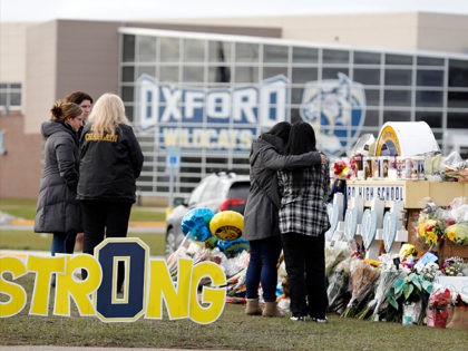 People gather at the memorial for the dead and wounded outside of Oxford High School in Oxford, Michigan on December 3, 2021. - The parents of a 15-year-old boy who shot dead four students at a high school in the US state of Michigan with a gun bought for him …