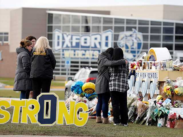 People gather at the memorial for the dead and wounded outside of Oxford High School in Ox