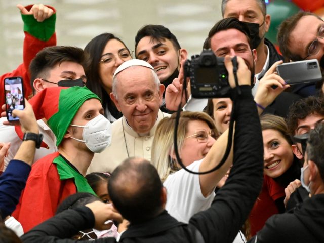 Pope Francis poses for photos with attendees during an audience to children cared for by the Santa Marta Dispensary, on December 19, 2021 at Paul-VI hall in The Vatican. (Photo by Alberto PIZZOLI / AFP) (Photo by ALBERTO PIZZOLI/AFP via Getty Images)