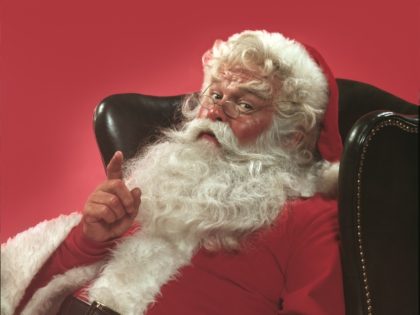 Portrait of Santa Claus sitting in a leather armchair raising one hand in a knowing gesture, 1980. United States. (Photo by Tom Kelley/Getty Images)