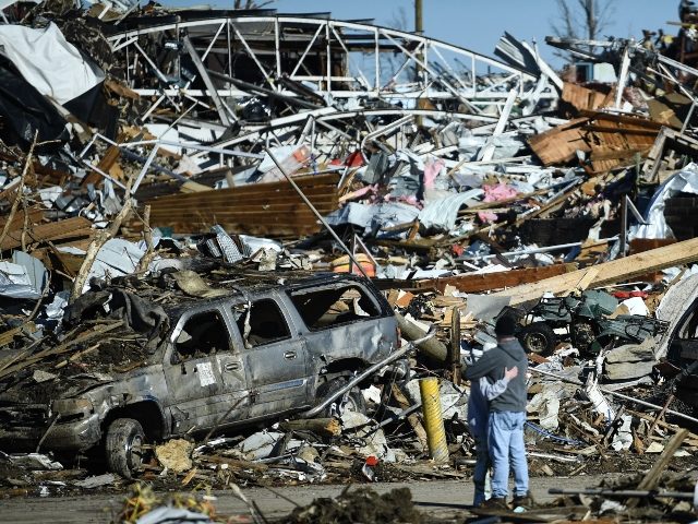 TOPSHOT - People embrace as tornado damage is seen after extreme weather hit the region December 12, 2021, in Mayfield, Kentucky. - Dozens of devastating tornadoes roared through five US states overnight, leaving more than 80 people dead Saturday in what President Joe Biden said was "one of the largest" …