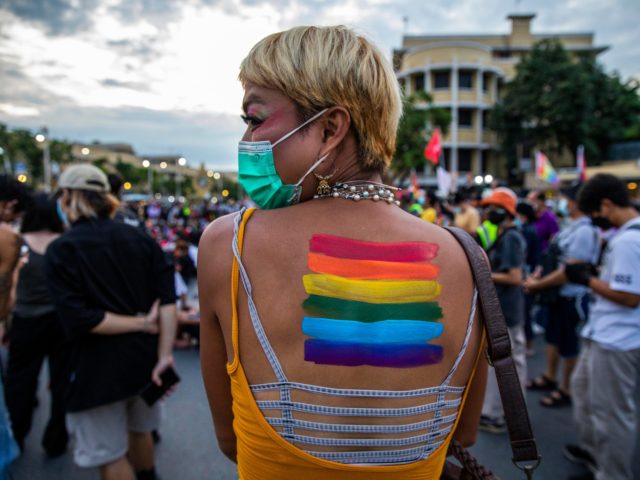 BANGKOK, THAILAND - OCTOBER 09: Tata, a member of the Feminist Liberation Front, has a rainbow flag painted on her back during a rally on October 9, 2021 in Bangkok, Thailand. The Feminist's Liberation Front is a democratic reform group focused on promoting gender equality and LGBTQ rights in Thailand. …
