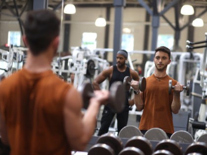 Gabriel Carvalho works out without a face mask a Fitness SF gym on October 15, 2021 in San Francisco, California. The City and County of San Francisco has started to ease indoor mask mandates today that allows groups of up to 100 vaccinated people to go without masks at gyms, …