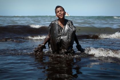 A boy removing oil spilled on Itapuama beach, in Cabo de Santo Agostinho, Pernambuco State