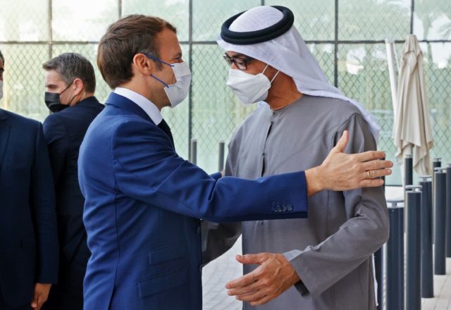 French President Emmanuel Macron (L) is greeted by Abu Dhabi's Crown Prince Mohammed bin Z