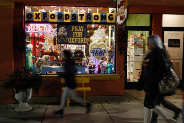 Signs in the window of a store show support for the community after the Oxford High School