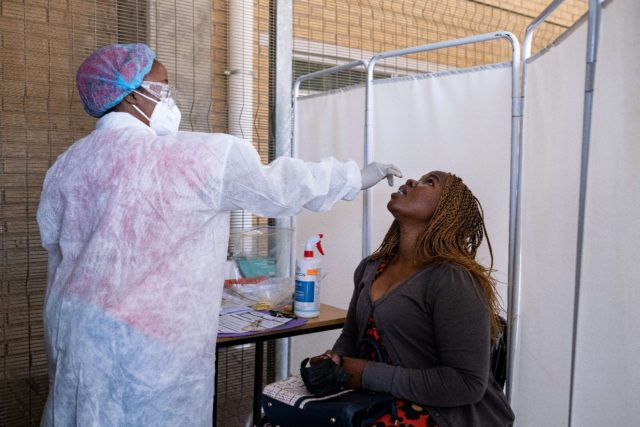 A health worker takes a Covid test sample at Lancet Laboratories in Johannesburg. The lab