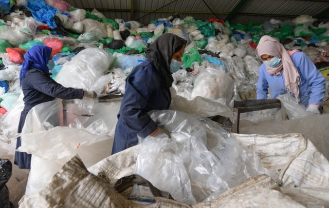Employees sort through piles of plastic waste at African Recycling, one of the few recycli