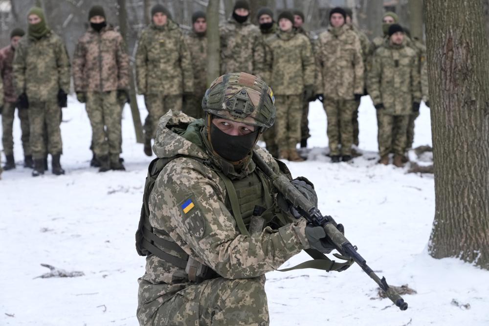 An instructor trains members of Ukraine's Territorial Defense Forces, volunteer military units of the Armed Forces, in a city park in Kyiv, Ukraine, Saturday, Jan. 22, 2022. Dozens of civilians have been joining Ukraine's army reserves in recent weeks amid fears about Russian invasion. (AP Photo/Efrem Lukatsky)
