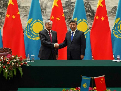 China's President Xi Jinping (R) shakes hands with Kazakhstan's President Kassym