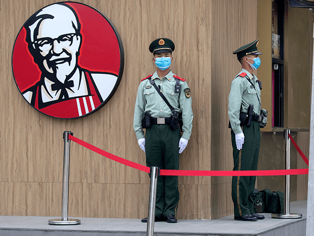 Chinese paramilitary policemen wearing masks to curb the spread of the new coronavirus stand guard near a logo for KFC before the opening session of the Chinese People's Political Consultative Conference (CPPCC) is to be held at the Great Hall of the People in Beijing, Thursday, May 21, 2020. (AP …