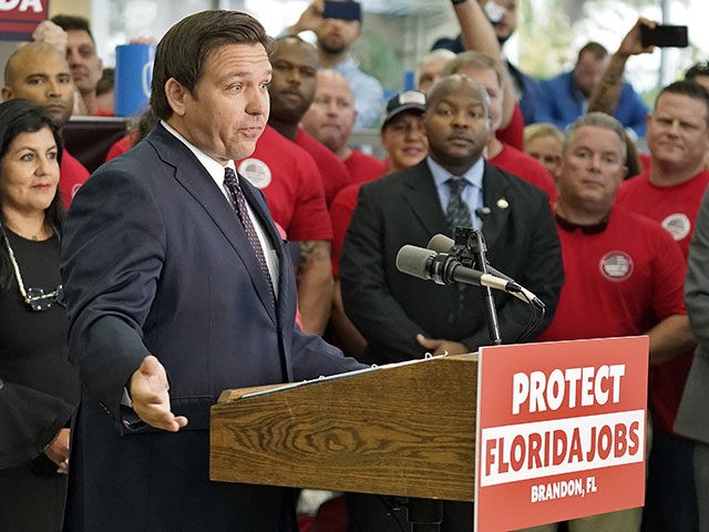 As supporter holds up a Brandon, Florida sign as Florida Gov. Ron DeSantis, center, speaks to members of the media before a bill signing Thursday, Nov. 18, 2021, in Brandon, Fla. Gov. DeSantis has embraced “Let’s go Brandon.” The Republican governor's campaign said they picked the small Tampa suburb of …