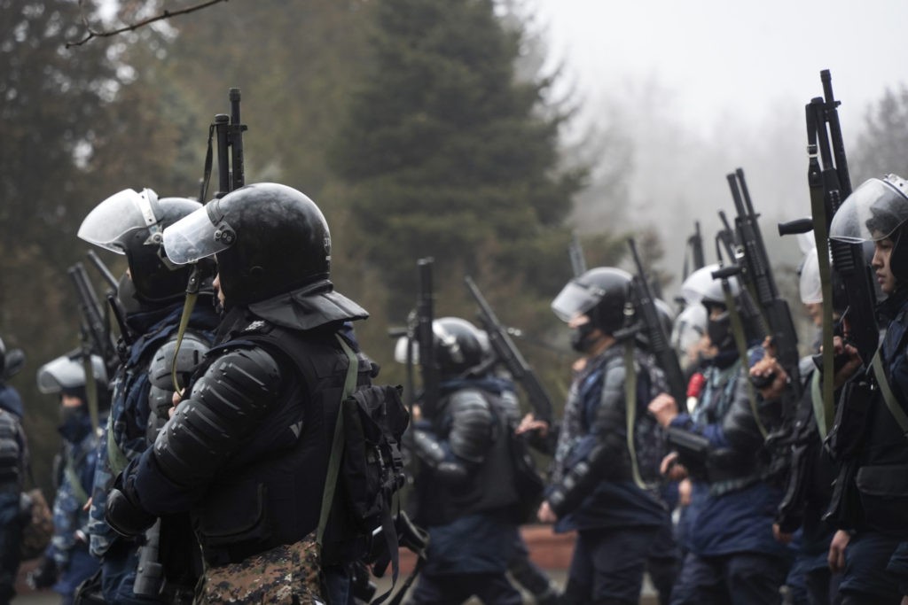Riot police officers hold their weapons ready as they try to stop demonstrators during a protest in Almaty, Kazakhstan, Wednesday, Jan. 5, 2022. Demonstrators denouncing the doubling of prices for liquefied gas have clashed with police in Kazakhstan's largest city and held protests in about a dozen other cities in the country. (AP Photo/Vladimir Tretyakov)