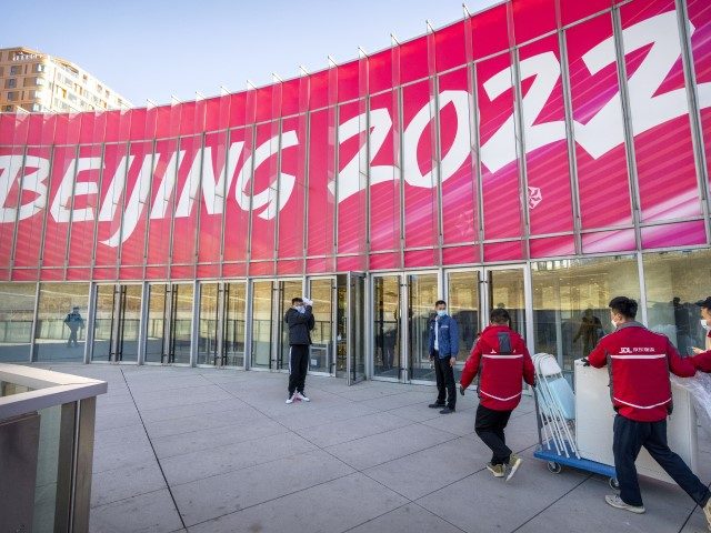 Workers deliver a cart loaded with equipment to a commercial plaza at the Winter Olympic Village in Beijing, Friday, Dec. 24, 2021. Organizers on Friday gave the media a look at parts of the athletes' Olympic Village for the 2022 Winter Olympics and Paralympics, which will be held beginning in …