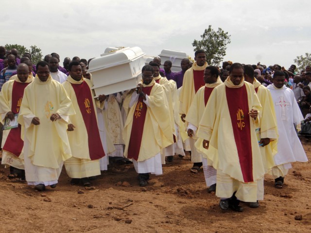 Clergymen carry coffins containing the bodies of priests and worshippers allegedly killed by Fulani herdsmen in north-central Nigeria on May 22, 2018.
