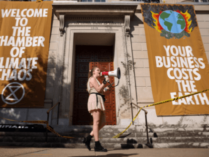 WASHINGTON, DC - OCTOBER 14: Climate activists hold a protest at the U.S. Chamber of Commerce after scaling the building on October 14, 2021 in Washington, DC. The group, Extinction Rebellion, led the rally against the U.S. Chamber of Commerce, calming the organization denials climate change and puts corporate profit …