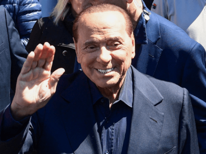 Former Italian prime minister and media tycoon Silvio Berlusconi smiles and waves to the m