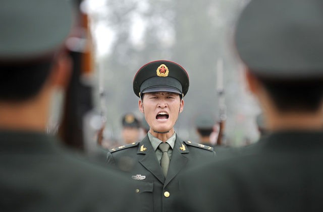 A military officer (C) shouts an order to soldiers of the Guards of Honour of the Three Services of the Chinese People's Liberation Army (PLA) during a training session at a barracks in Beijing on July 21, 2011. The honour guard troops were established in March 1952 and is the …